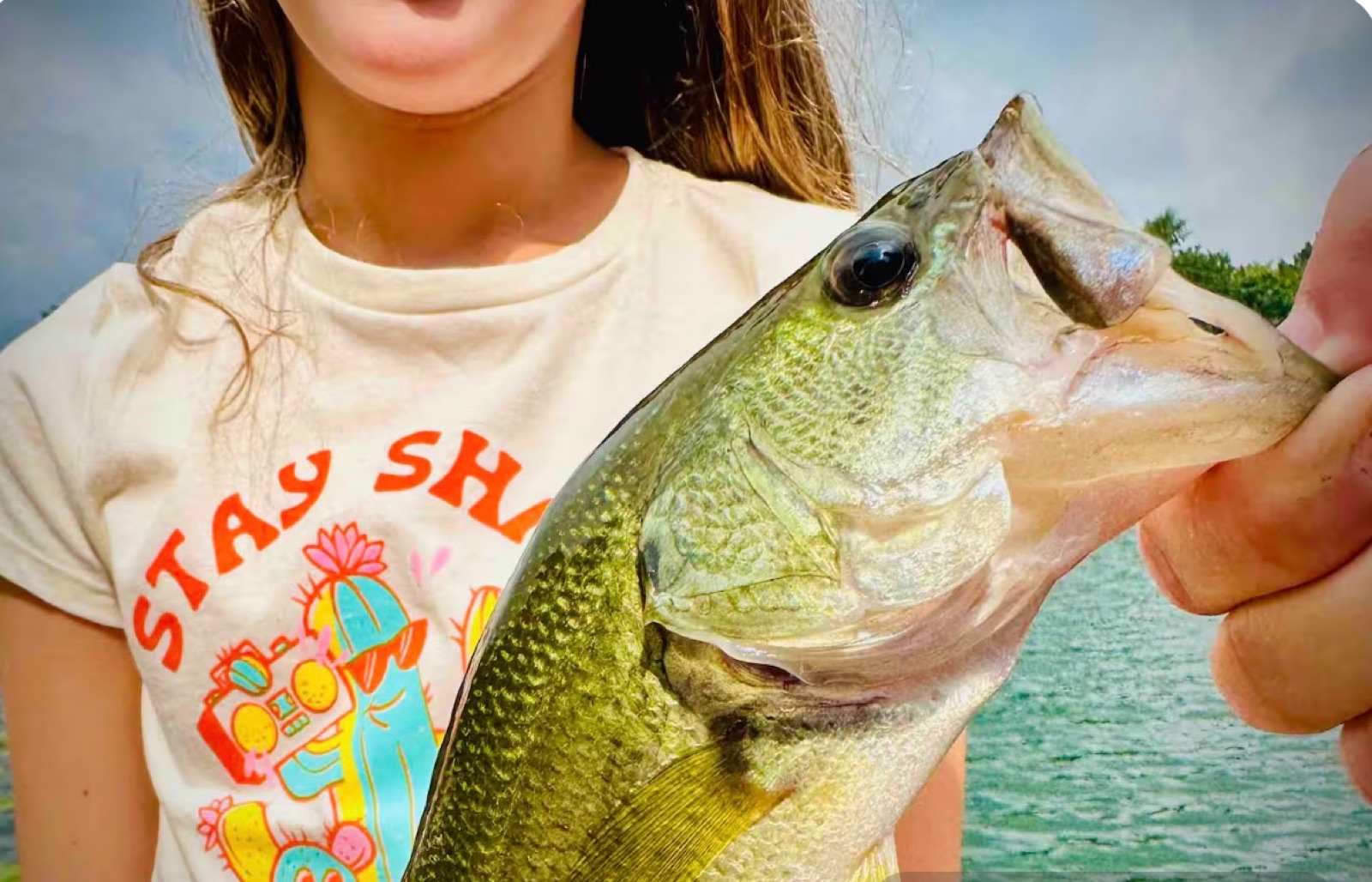 A young guest showing off a largemouth bass caught on Lake Huyck